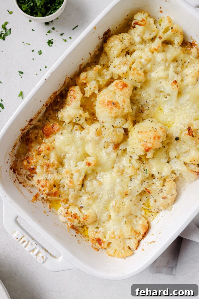 Freshly baked cauliflower au gratin resting on a wooden board.