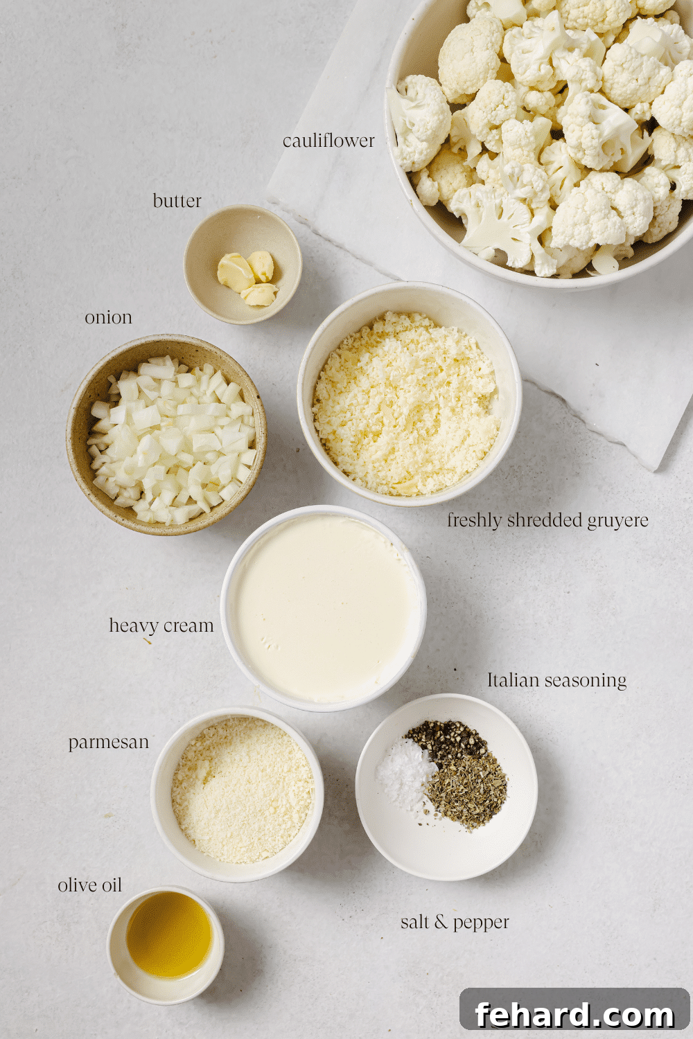 Pre-measured ingredients for cauliflower au gratin, including cauliflower, butter, cream, and cheese.