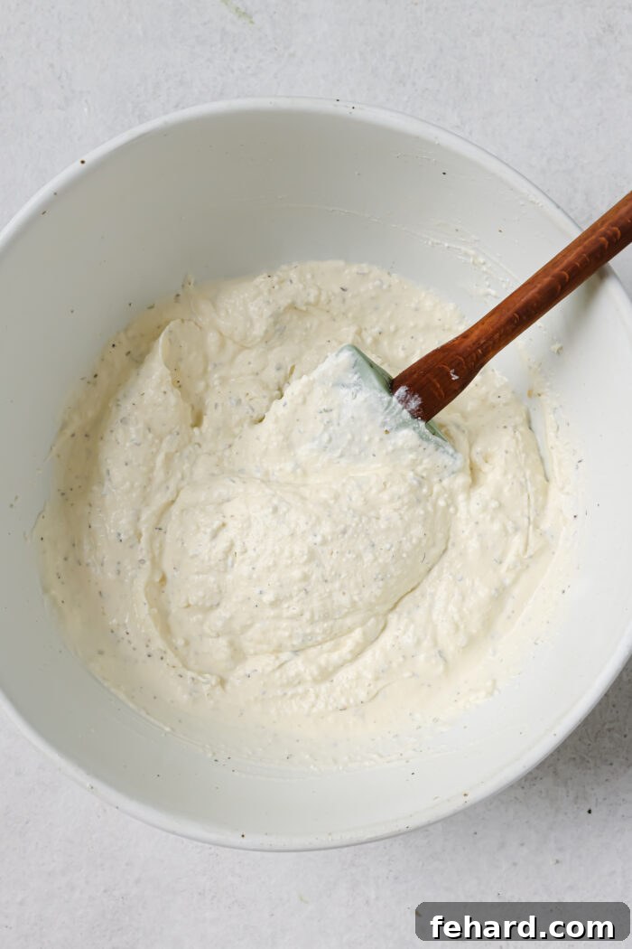 Heavy cream and grated Parmesan cheese in a mixing bowl.