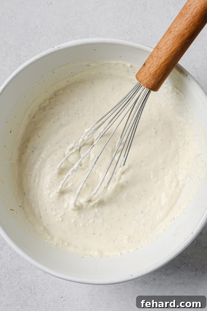 Italian seasoning, salt, and pepper being added to the cream mixture.