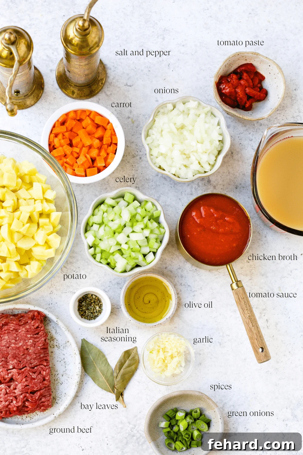 All the pre-measured ingredients for homemade hamburger soup meticulously arranged on a kitchen counter, ready for cooking.