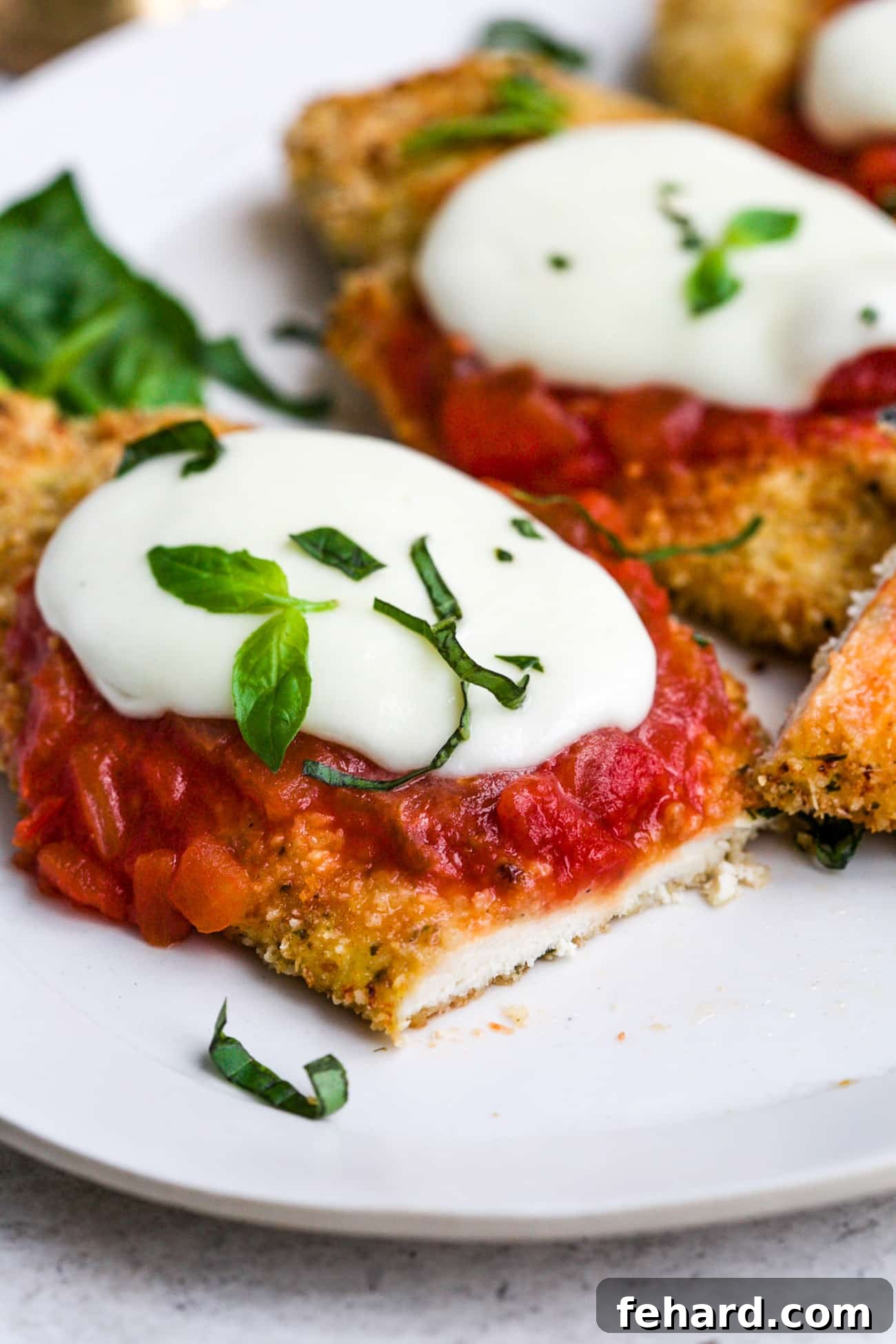 Homestyle Chicken Parmesan Bake 7 Baked chicken parmesan on a white serving plate.