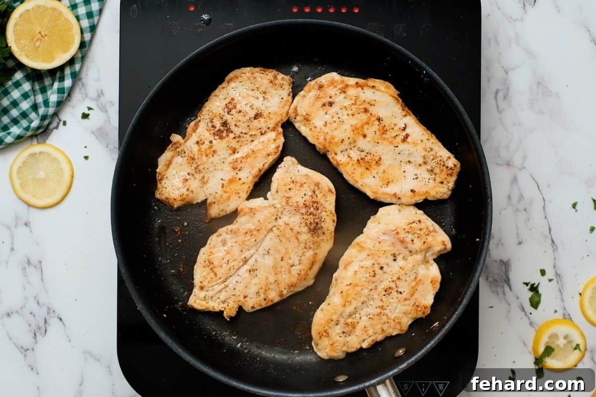Chicken Cutlet Recipe Golden-brown pan-seared chicken cutlets resting in a skillet, ready for sauce.
