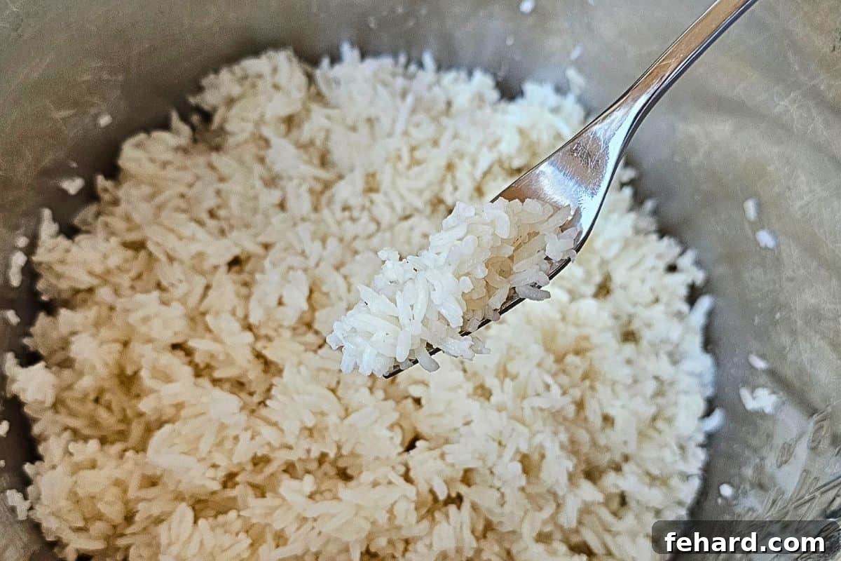 A forkful of perfectly fluffy white rice inside the Instant Pot's inner pot, ready to be served.