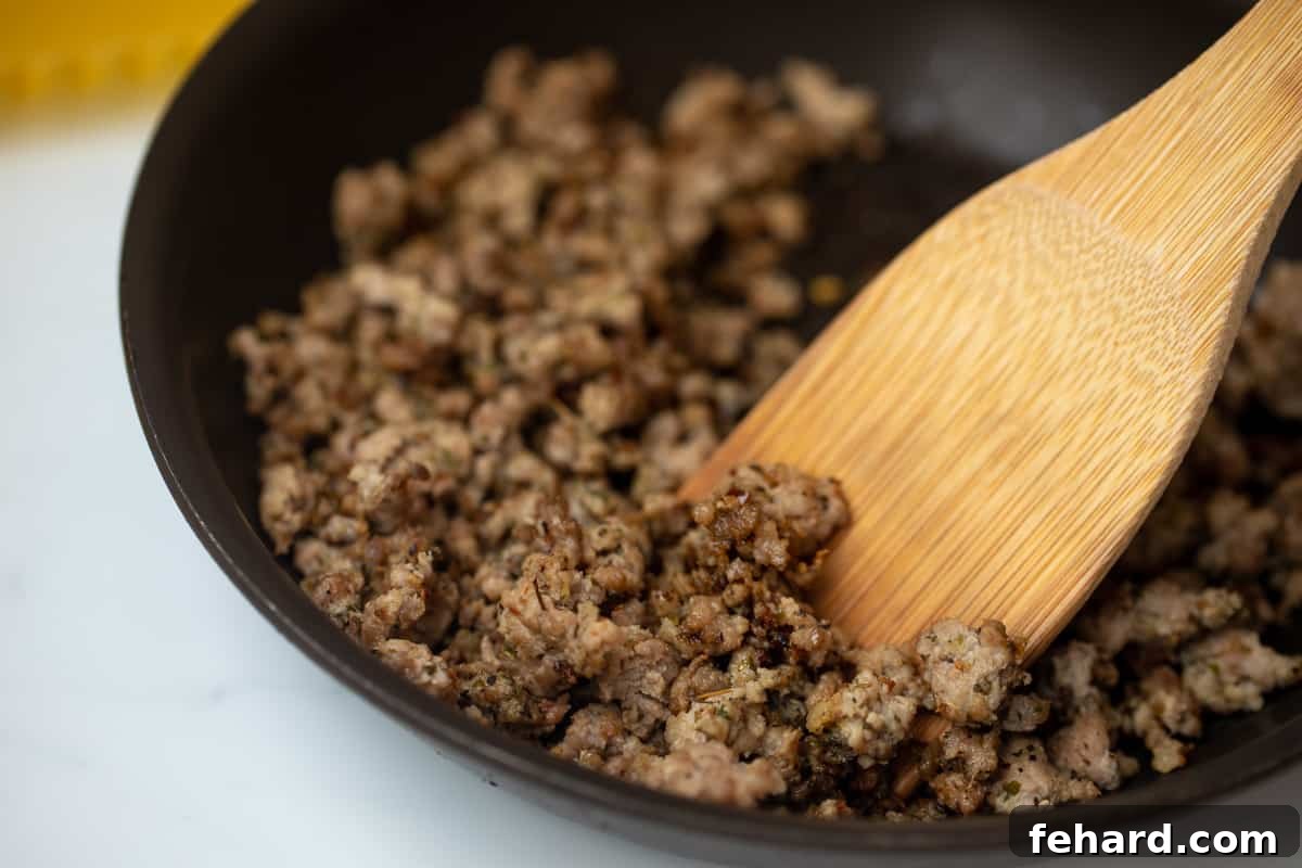 Homemade Italian Sausage Recipe Easy Cooking Spatula sauteeing homemade Italian sausage in a skillet with perfect browning.