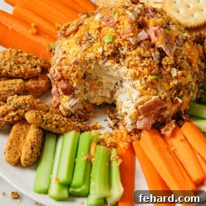 Cheese Ball on a plate with vegetables, crackers, and bread sticks.
