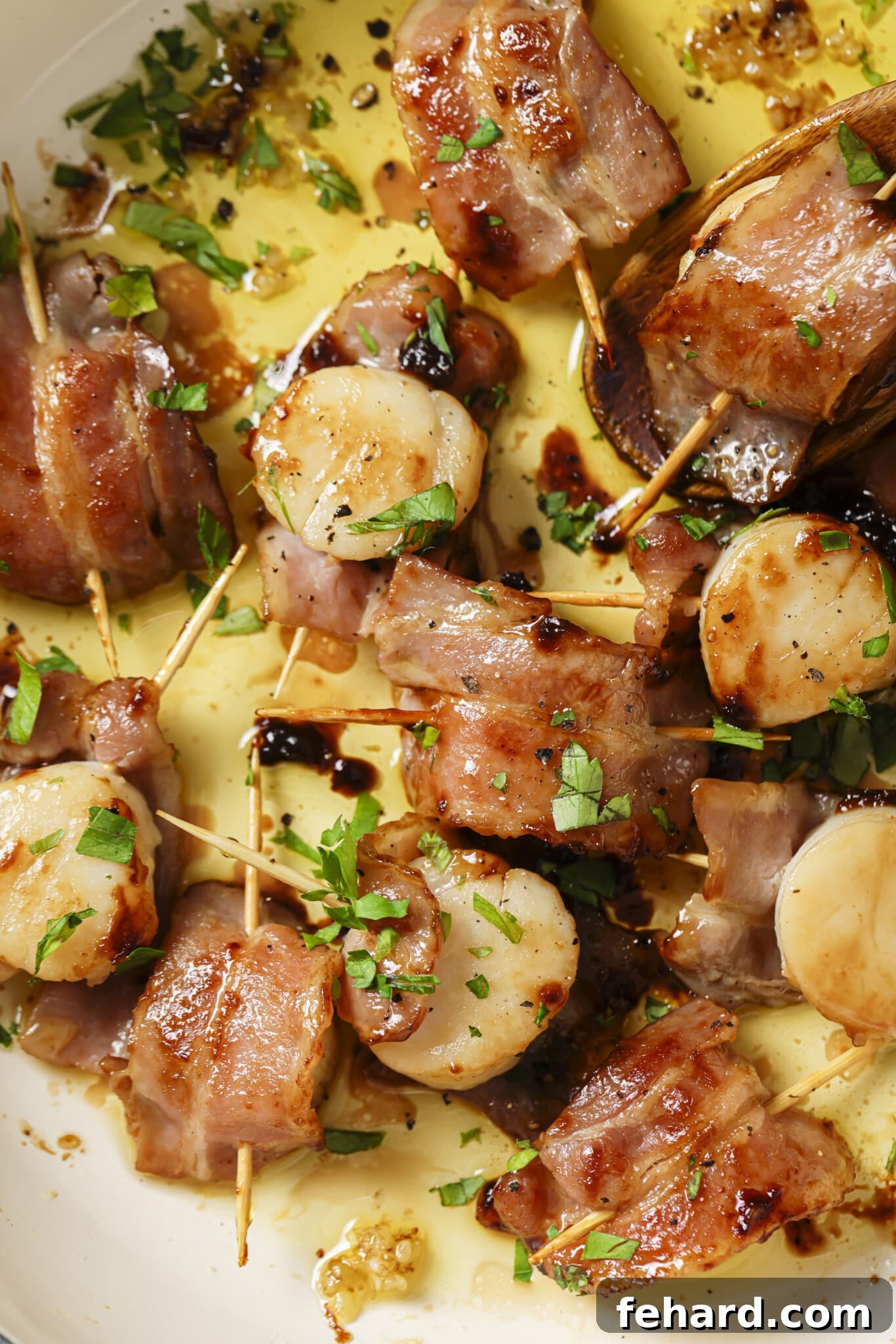 Ocean Jewels in a Crispy Embrace 6 Close up of a plate of Bacon Wrapped Scallops, garnished with fresh parsley and drizzled with garlic butter, ready to be enjoyed.