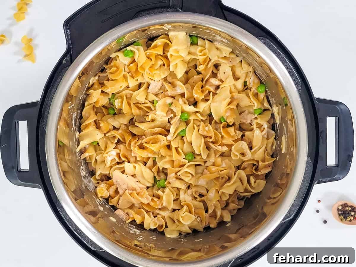 Close-up of freshly prepared Instant Pot Tuna Noodle Casserole, ready to be served from the pot, with steam rising.