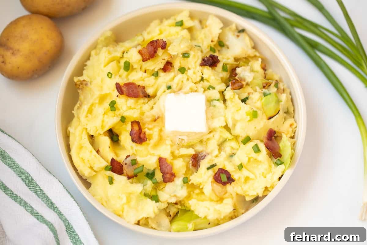 Colcannon served in an elegant dish, topped with a generous pat of butter, crispy bacon, and a sprig of fresh herbs.