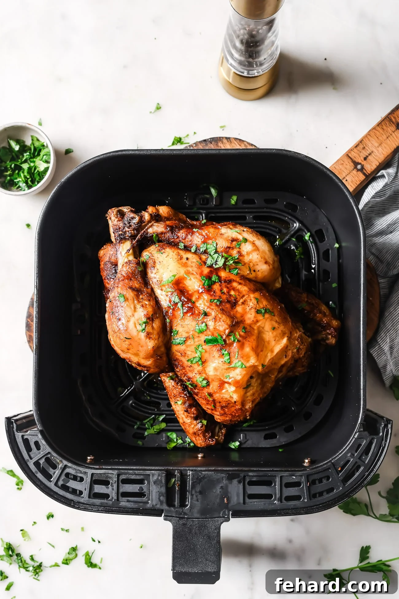 A cooked whole chicken in the air fryer, golden brown and perfectly crisp.