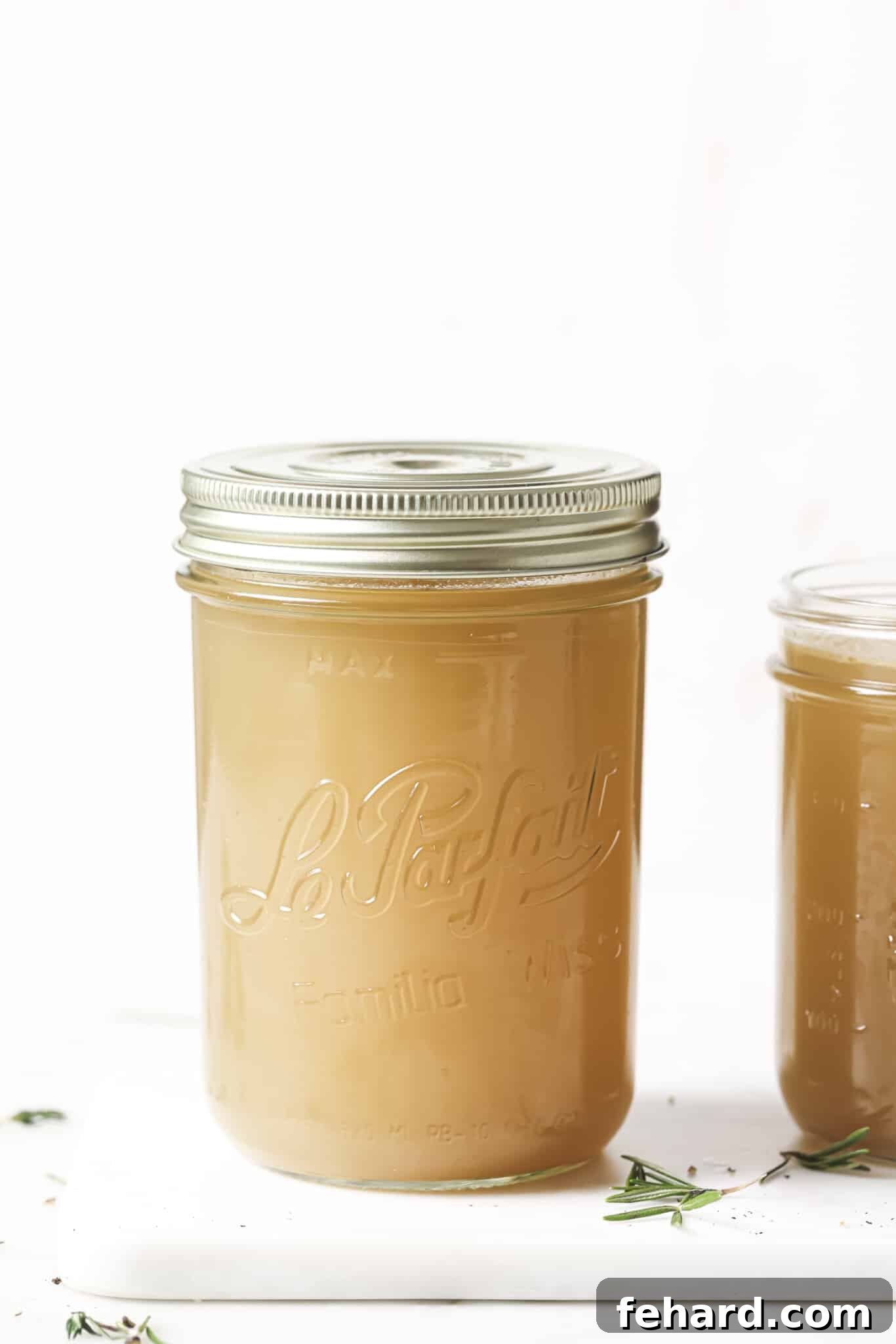 Freshly made homemade chicken broth in a mason jar, showcasing its golden color.