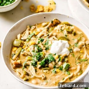 A bowl of delicious White Chicken Chili with a side of toppings.