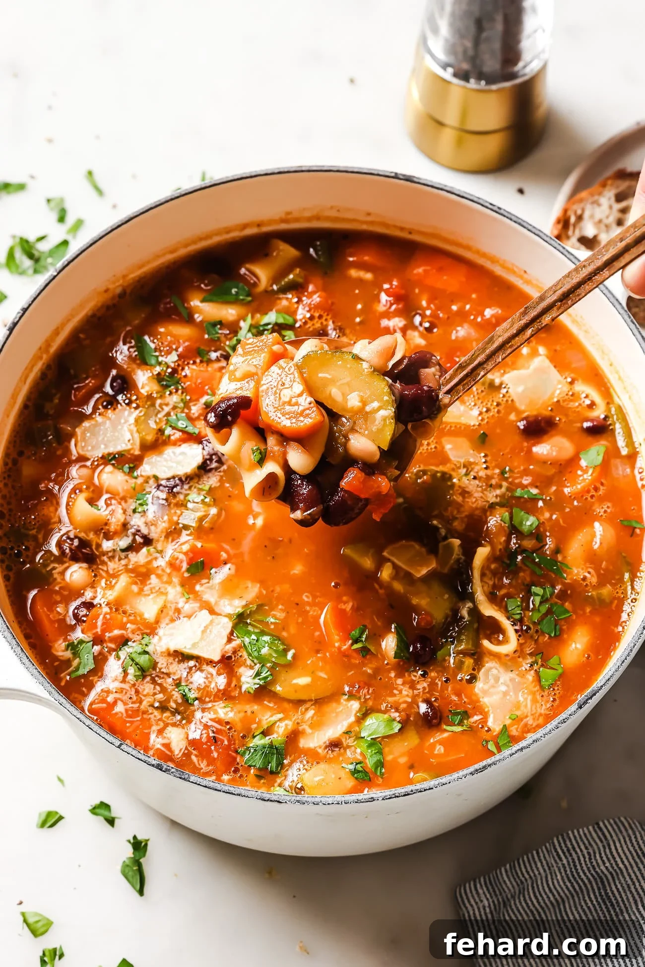 Hearty Vegetable Minestrone 6 A beautifully presented bowl of Minestrone Soup, artfully garnished with fresh parsley and delicate shavings of parmesan cheese, ready to be served.