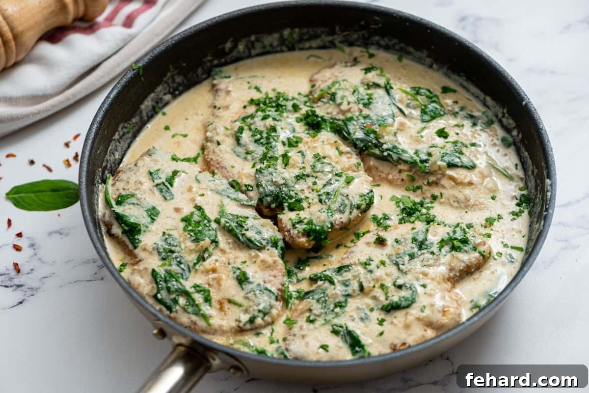 Italian Chicken Florentine Ready to Enjoy Tender chicken cutlets nestled in a skillet, beautifully coated in the creamy, vibrant spinach Florentine sauce, glistening and ready to be served.