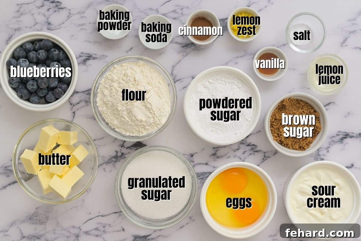 A perfectly arranged display of fresh ingredients for Lemon Blueberry Coffee Cake, including fresh lemons, plump blueberries, butter, sour cream, and various baking essentials on a kitchen counter.