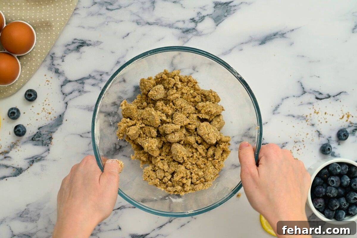 Close-up of brown sugar streusel mixture, showing the crumbly texture after cold butter has been incorporated into the flour and sugar.