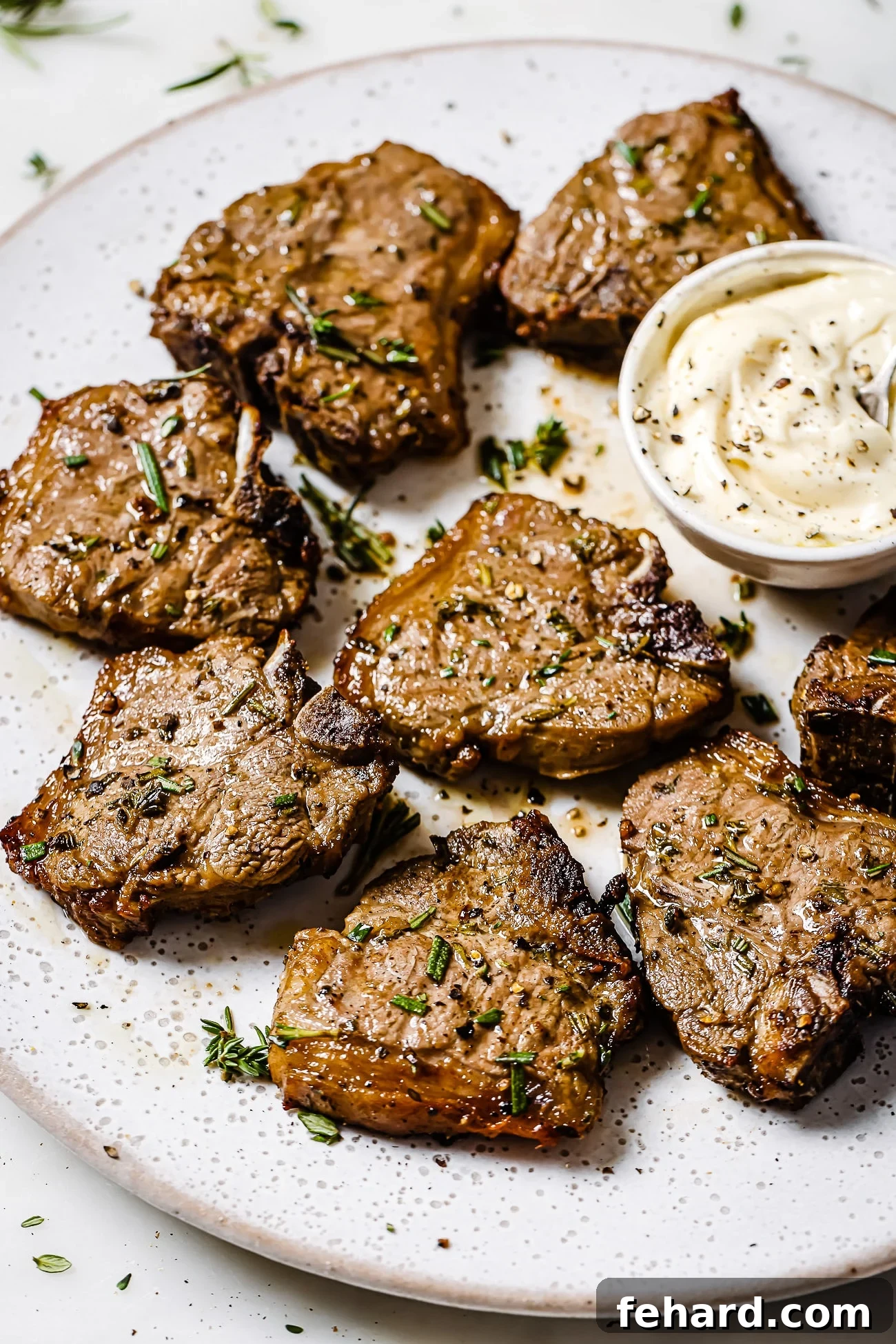 Close up of air fryer lamb chops on a white serving plate. 