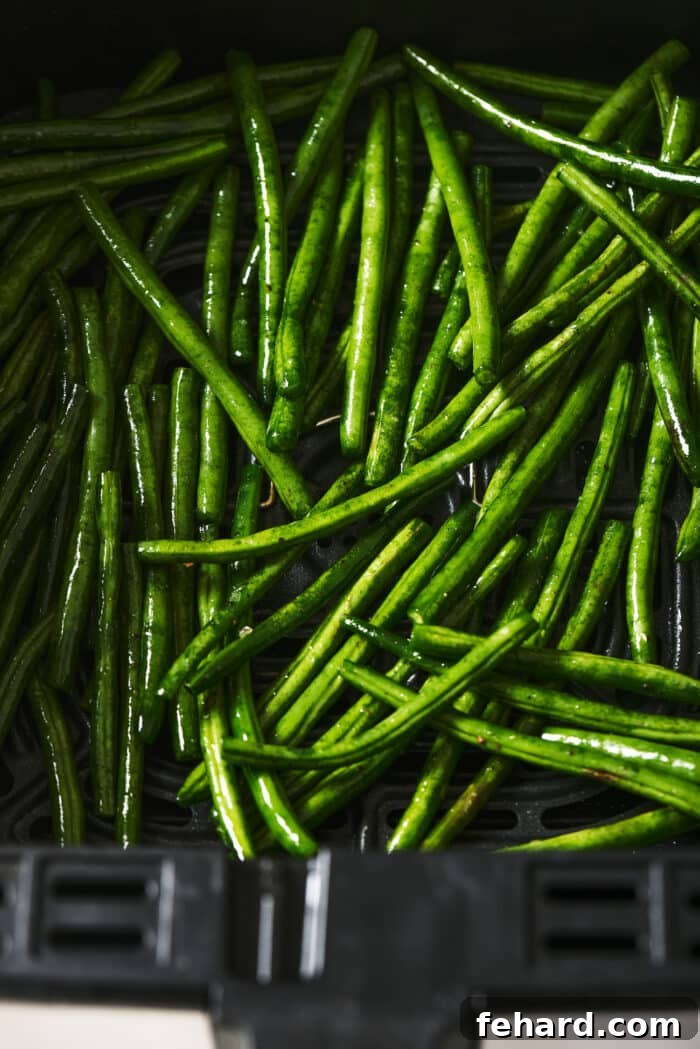 Crispy Air Fried Green Beans 5 Green beans arranged in a single layer in an air fryer basket.