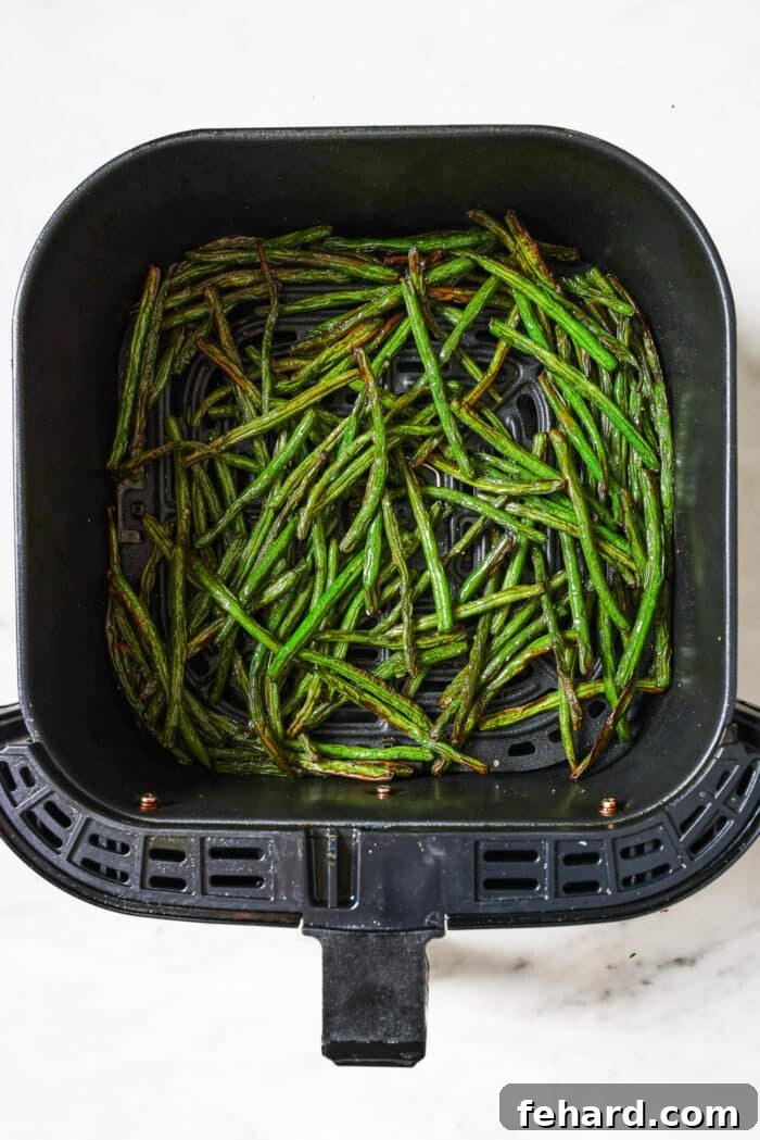 Crispy Air Fried Green Beans 6 Crispy green beans cooking in an air fryer basket.