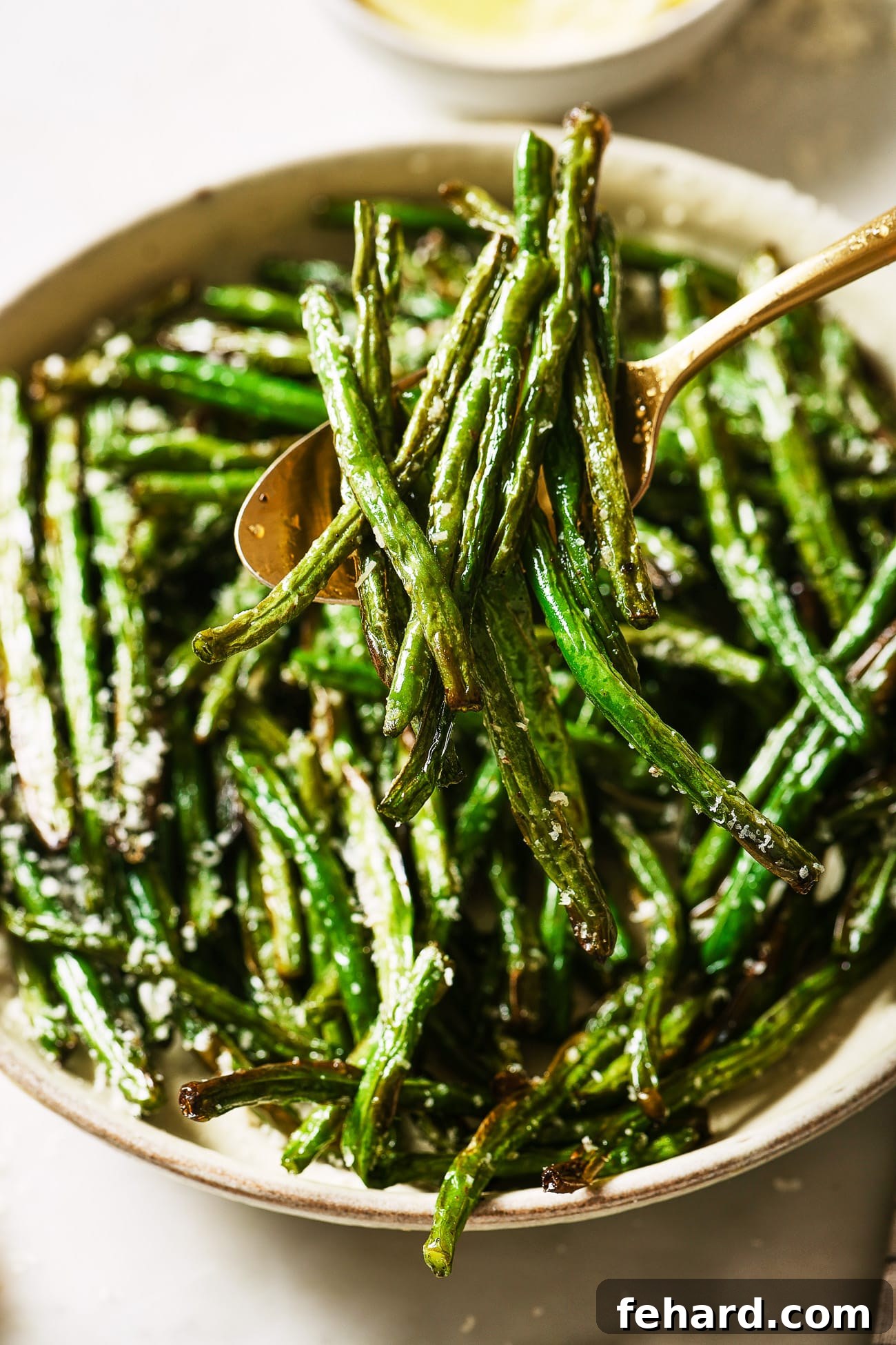 Crispy Air Fried Green Beans 8 A close up of air fryer green beans with a spoon dishing out a serving.
