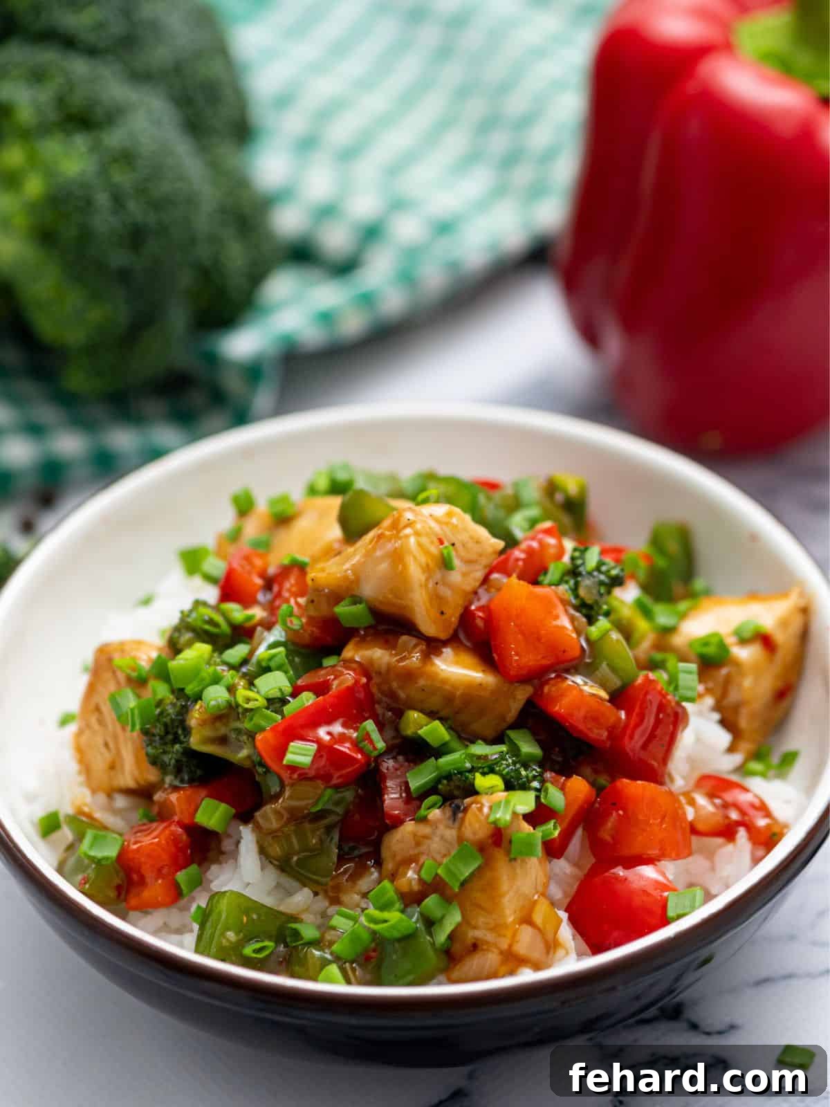 Recipe for Hunan Chicken A vibrant bowl of Hunan Chicken, featuring succulent chicken pieces and colorful vegetables, served over fluffy white rice. The dish is perfectly garnished and ready to enjoy.