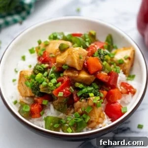 Fiery Hunan Chicken 3 Bowl of Homemade Hunan Chicken served over rice and topped with minced green onion, ready to eat.