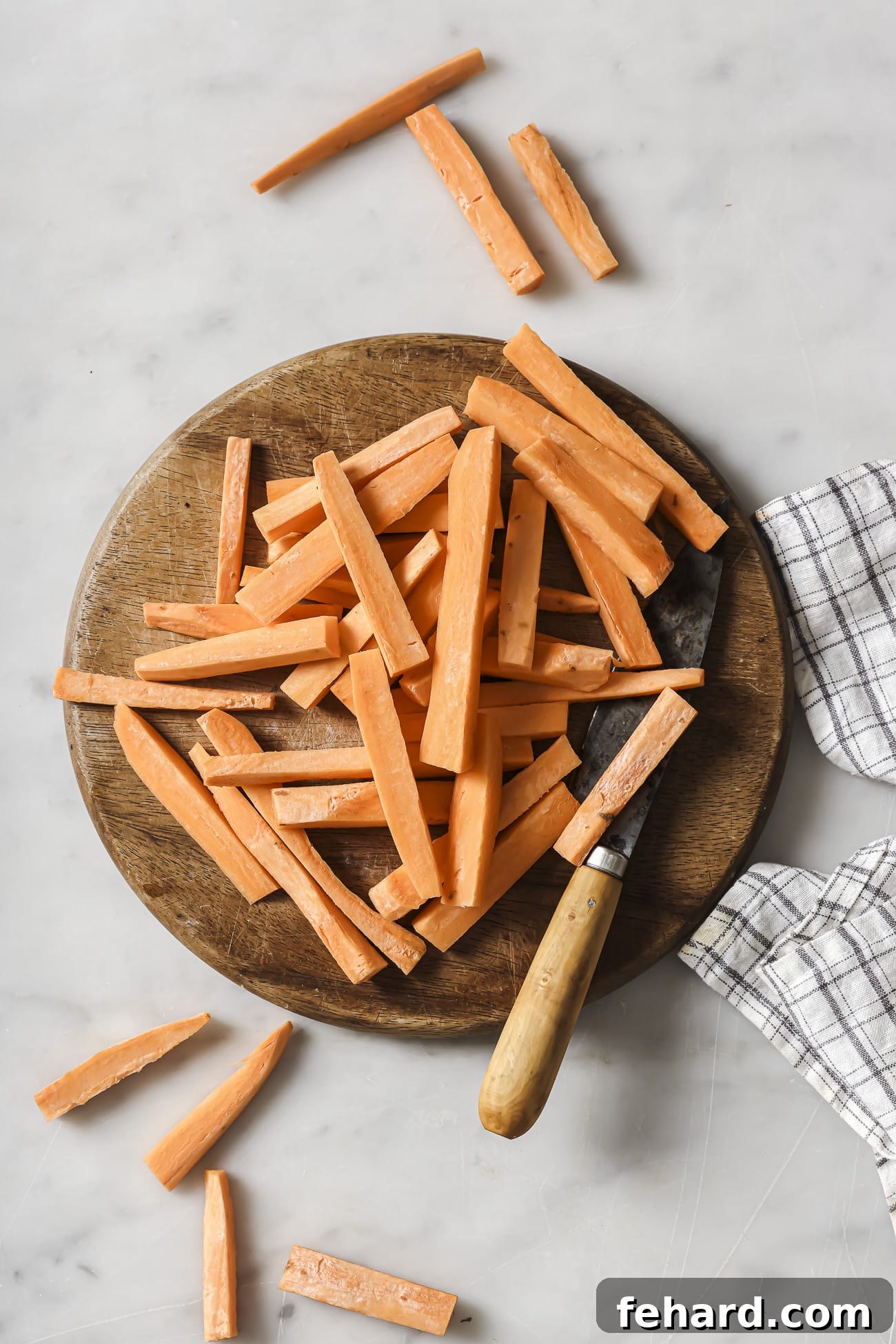 Crispy Air-Fried Sweet Potato Perfection 4 Sweet potatoes on a cutting board cut into sticks.