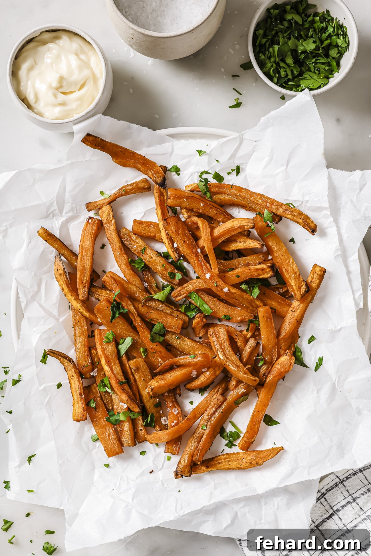Crispy Air-Fried Sweet Potato Perfection 7 Air fryer sweet potatoes with garnish and dipping sauce on the side.