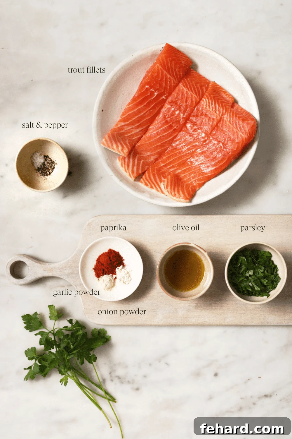 Pre-measured ingredients in small bowls, including trout fillets, olive oil, and spices.
