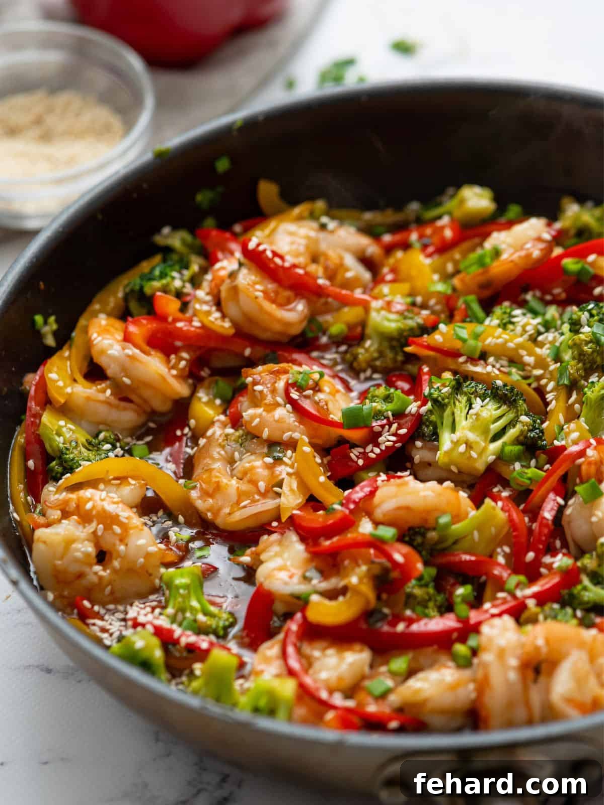 Zesty Shrimp Wok 2 A vibrant skillet showing freshly cooked shrimp stir fry with a medley of vegetables and a rich stir fry sauce, ready to be served.