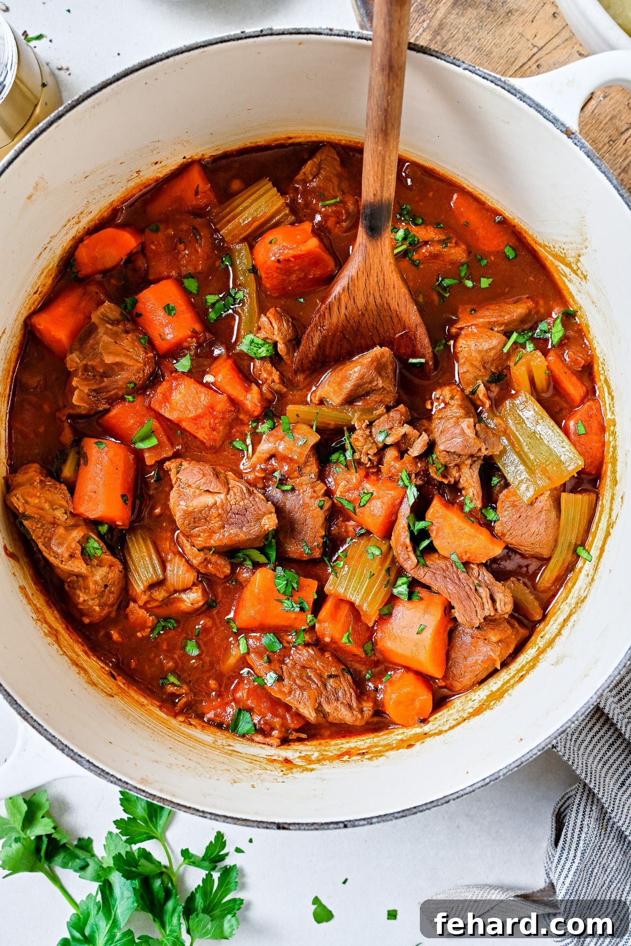 Lamb stew in a white Dutch oven.