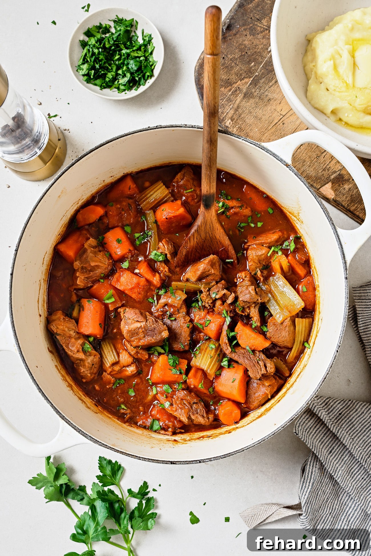 Lamb stew in a white Dutch oven.