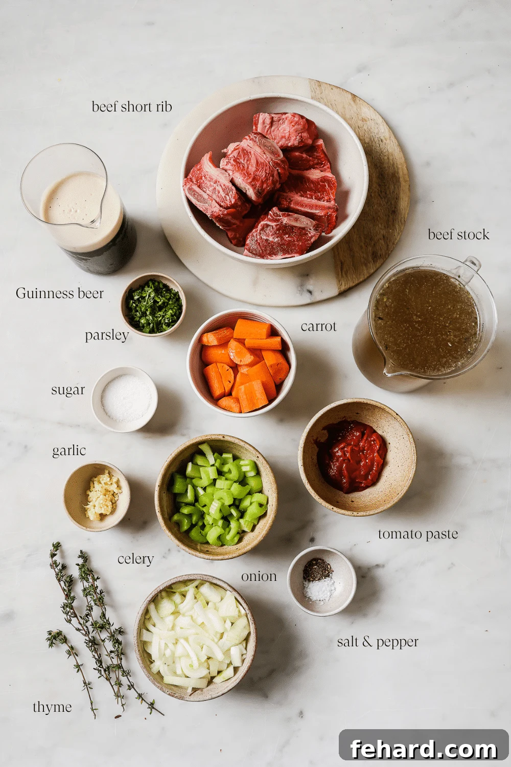 All the ingredients to make the Guinness Short Ribs on a white marble countertop.