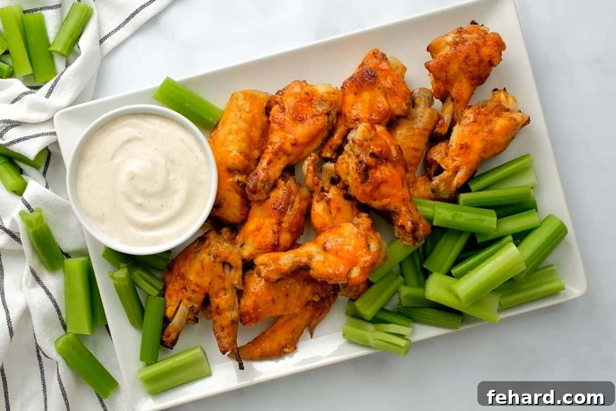 Crispy buffalo chicken wings served alongside cool ranch dressing and fresh celery sticks, highlighting the perfect pairing.