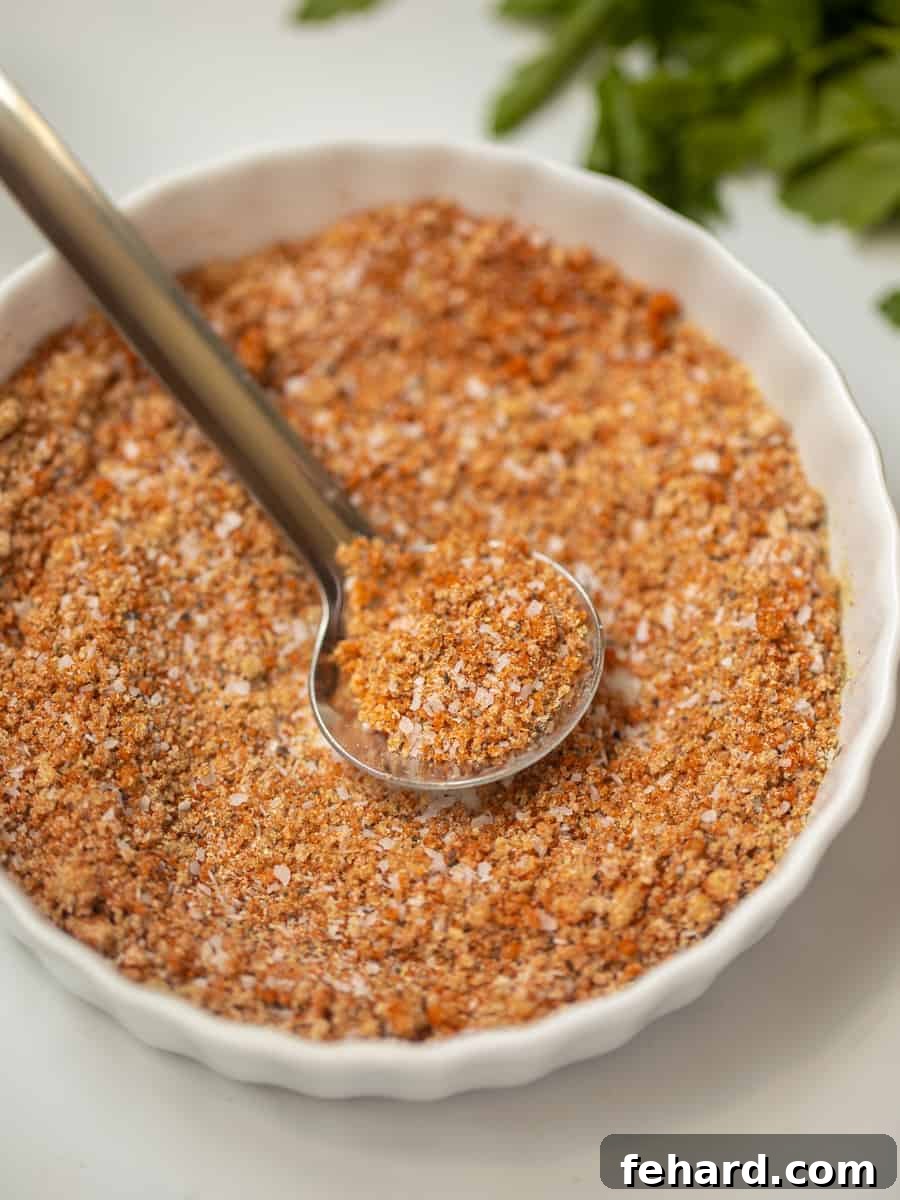Small white bowl with ingredients for homemade dry rub combined together. This all-purpose dry rub adds perfect flavor to burgers, steak, and BBQ.