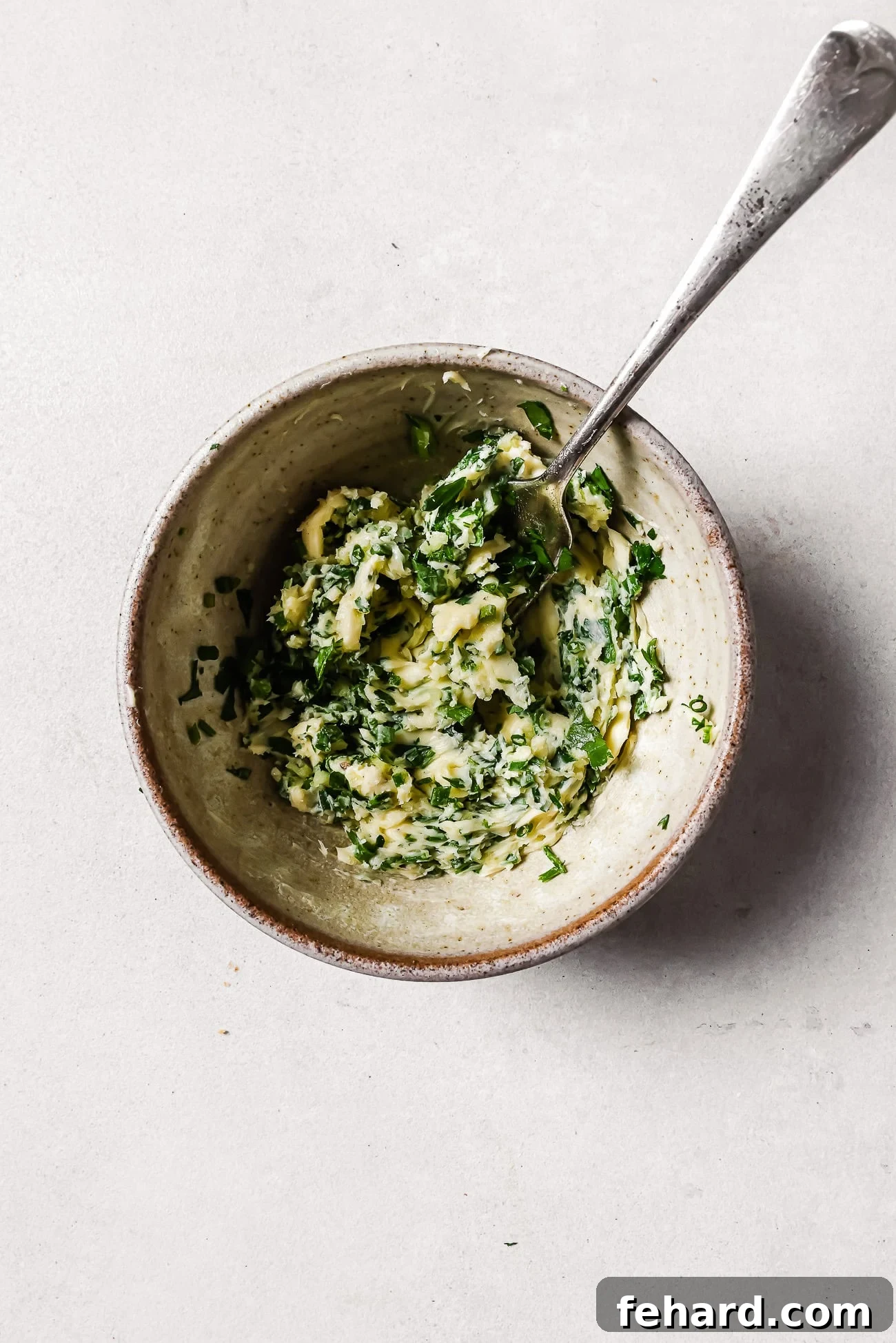 A bowl of compound butter with a spoon in it.