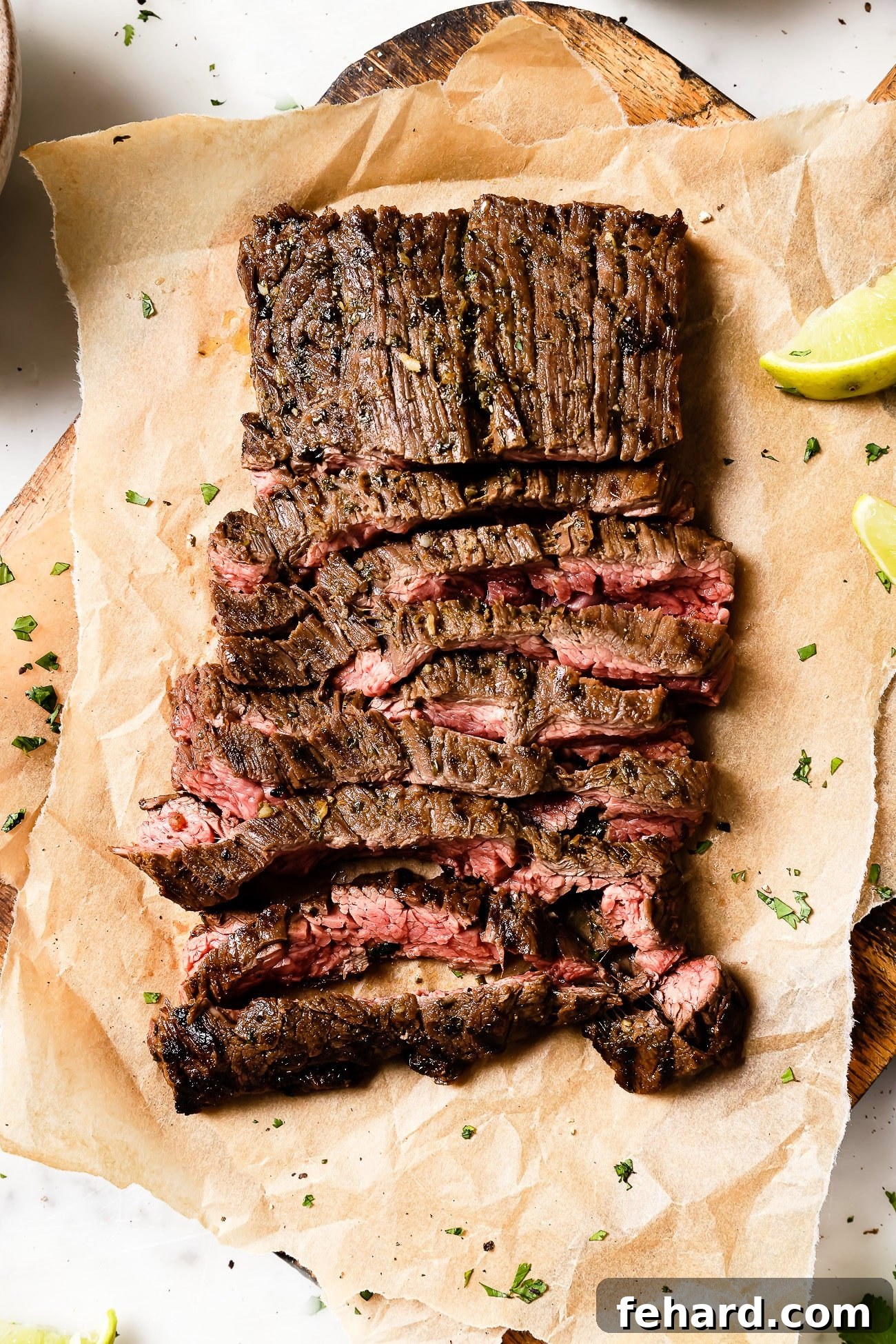 Sliced carne asada on parchment paper.