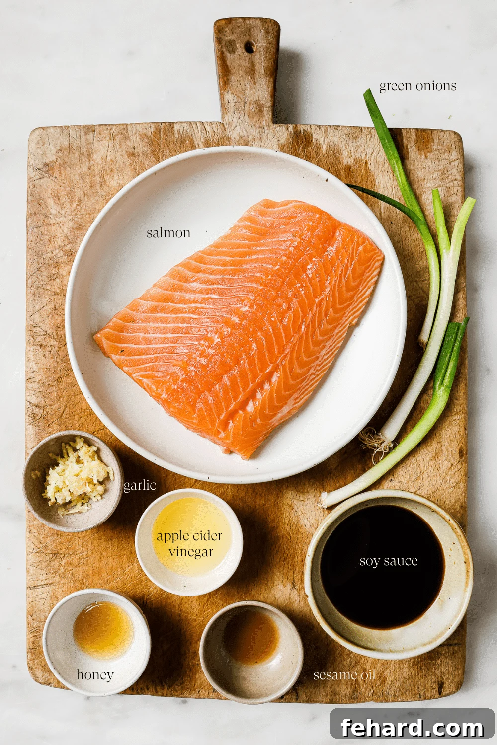Pre-measured marinade ingredients, including soy sauce, honey, garlic, and sesame oil, displayed on a wooden cutting board.