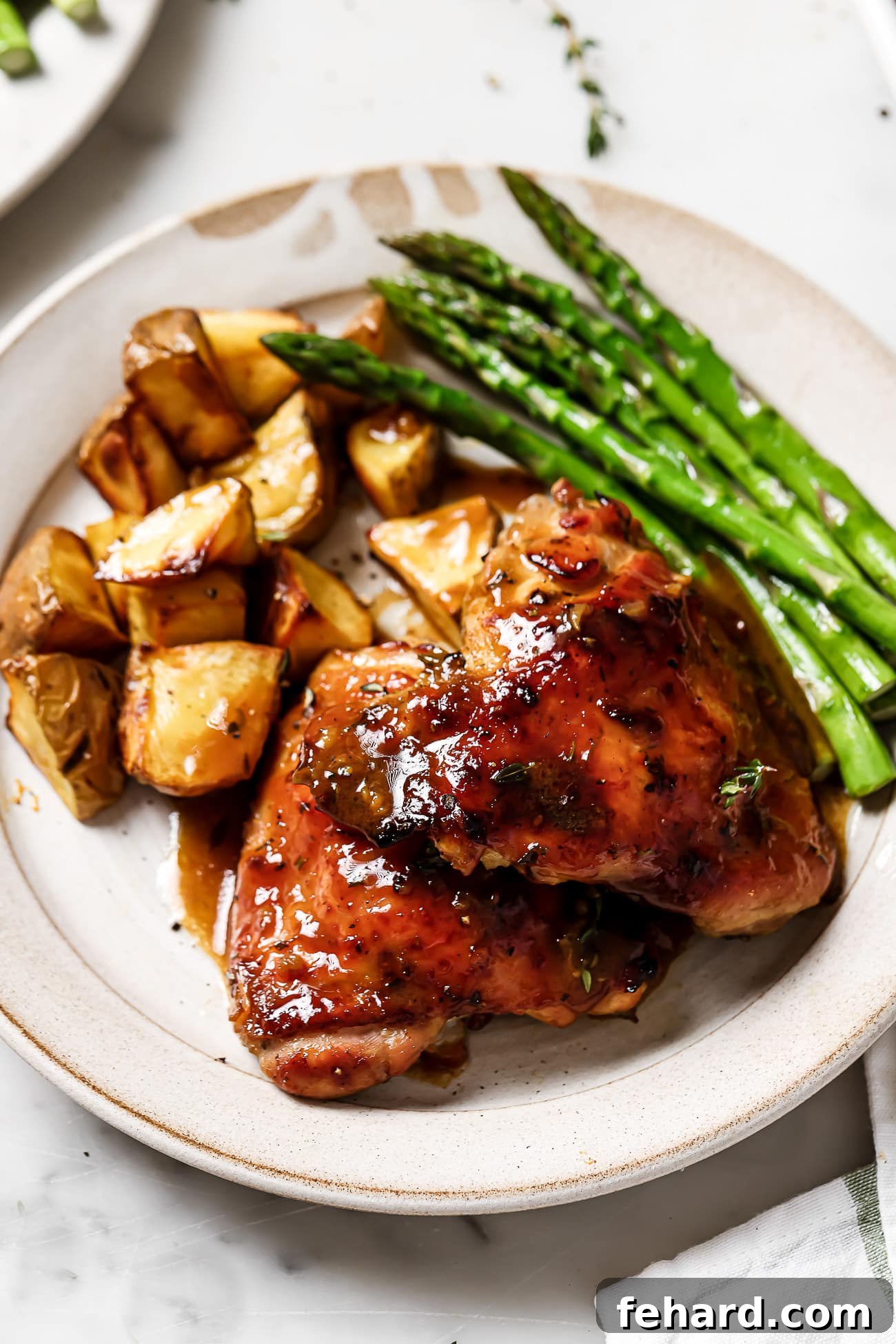 Golden Glazed Honey Mustard Chicken 2 Honey Mustard Chicken on a plate with asparagus and potatoes.