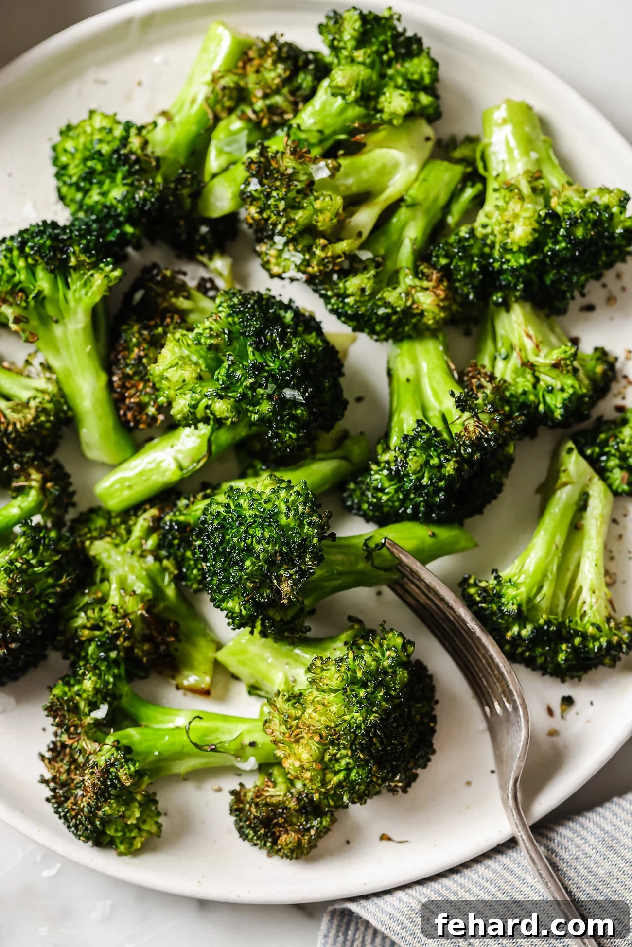 Quick & Crispy Air Fryer Broccoli 6 Air fryer broccoli on a white plate, ready to be stored or served.