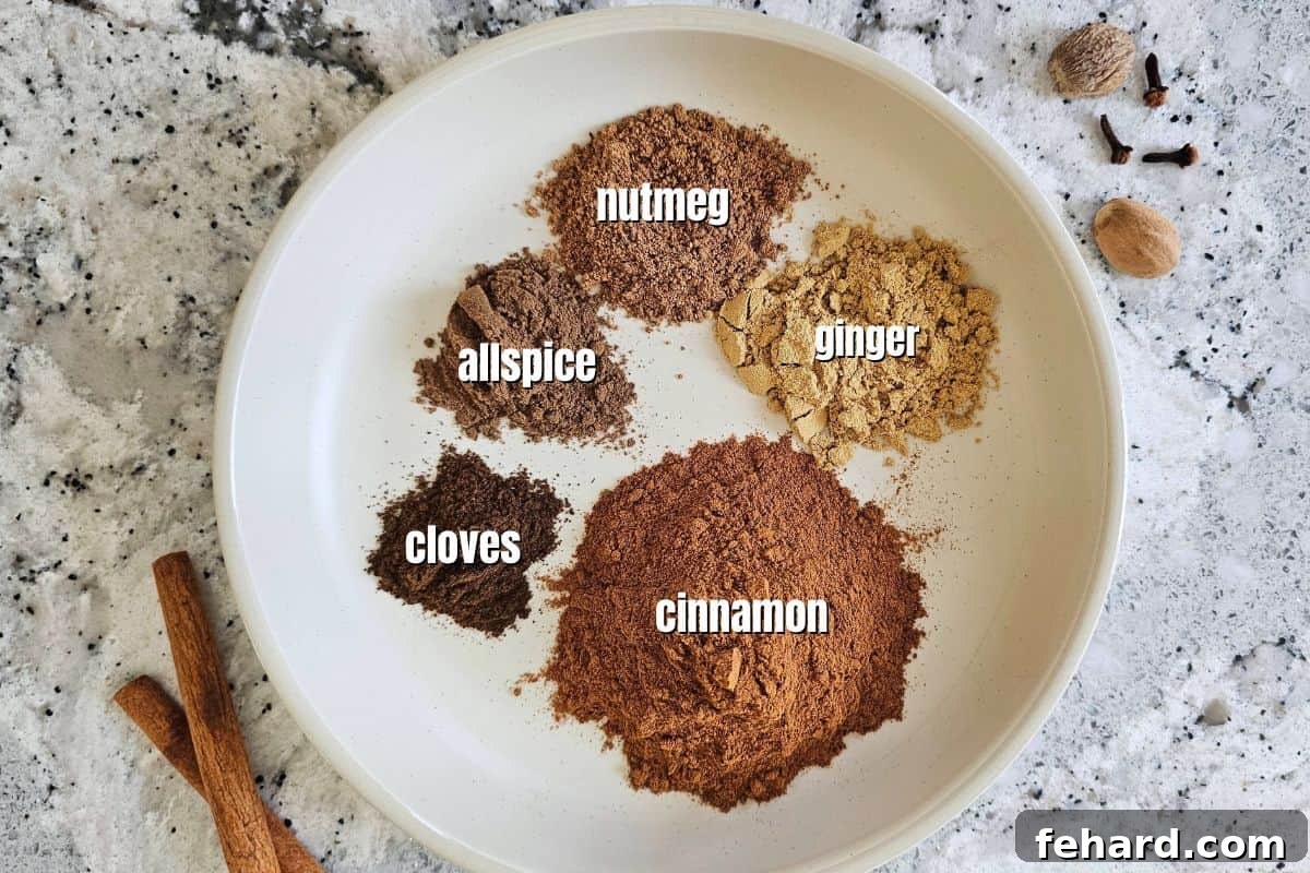 Individual spices for pumpkin pie seasoning, measured and clearly labeled in separate bowls: ground cinnamon, ginger, nutmeg, cloves, and allspice.
