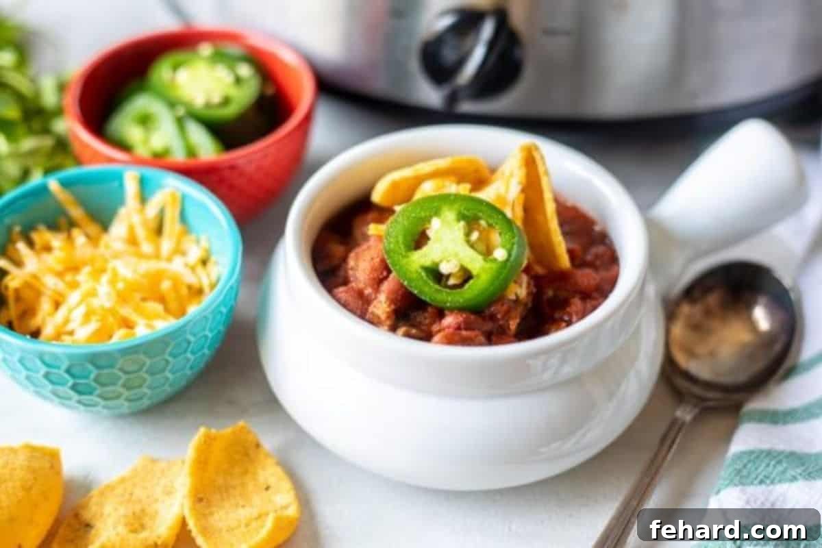 Best Chili Recipes for Every Craving A vibrant bowl of chili, generously topped with crispy corn chips, fresh cilantro, and fiery pickled jalapeños, ready to be enjoyed.