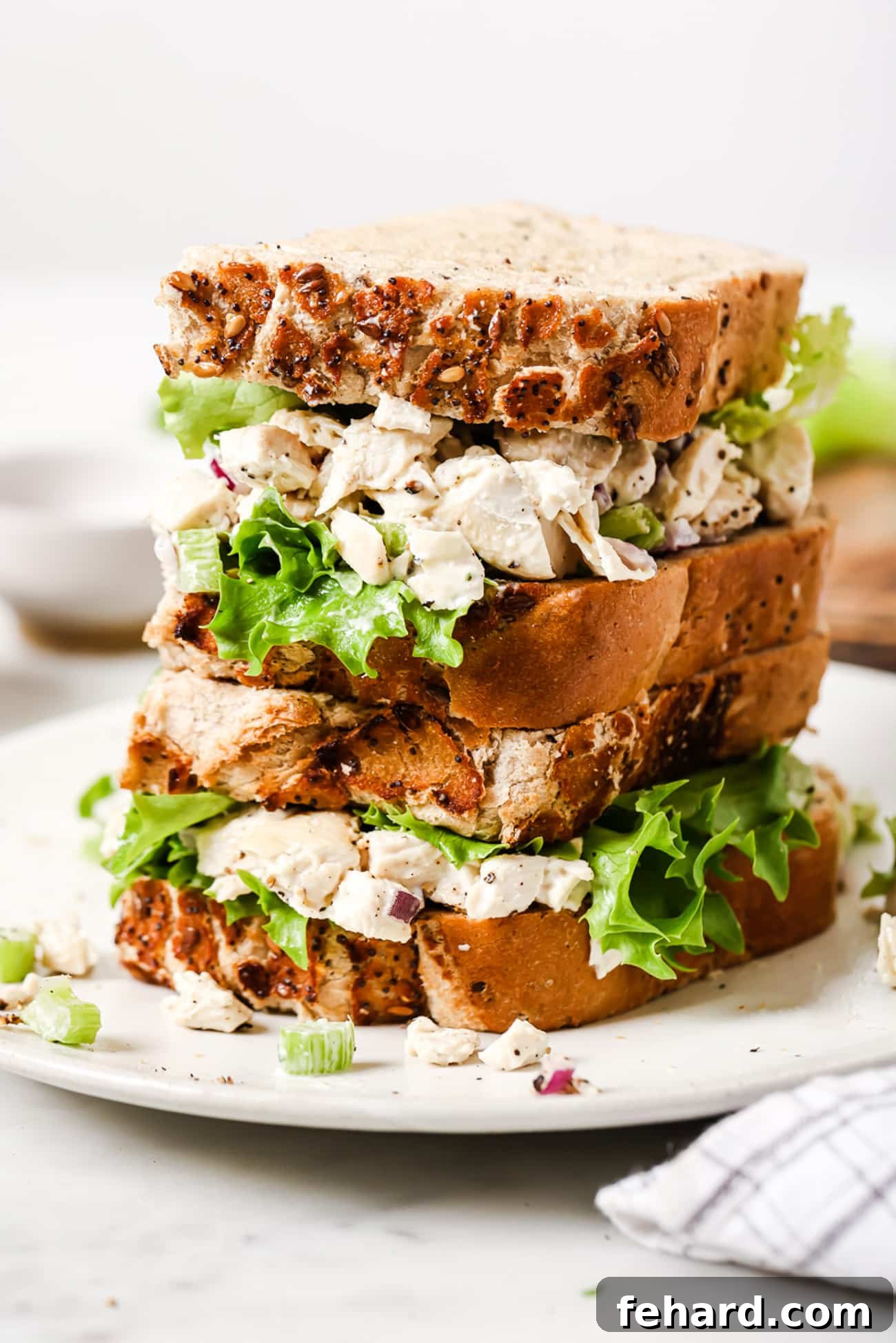 Signature Chicken Salad 7 Two perfectly made chicken salad sandwiches, artfully stacked on top of each other, ready to be enjoyed.