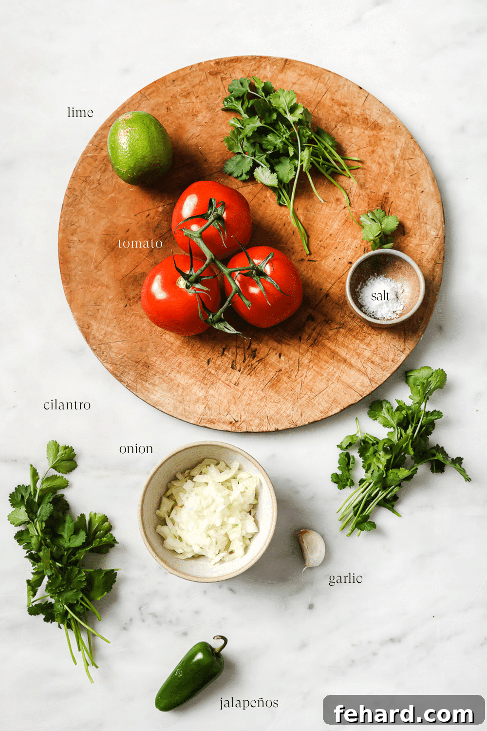 Vibrant Fresh Salsa 3 Fresh Pico de Gallo ingredients, including ripe tomatoes, white onion, jalapeño, cilantro, lime, and garlic, neatly arranged on a wooden cutting board against a white marble countertop, ready for preparation.