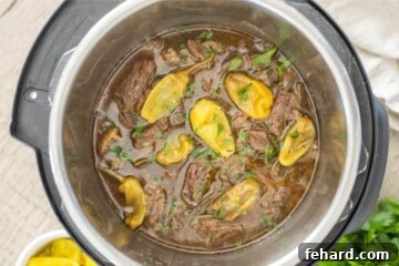 Shredded pot roast inside inner pot with pepperoncini peppers.