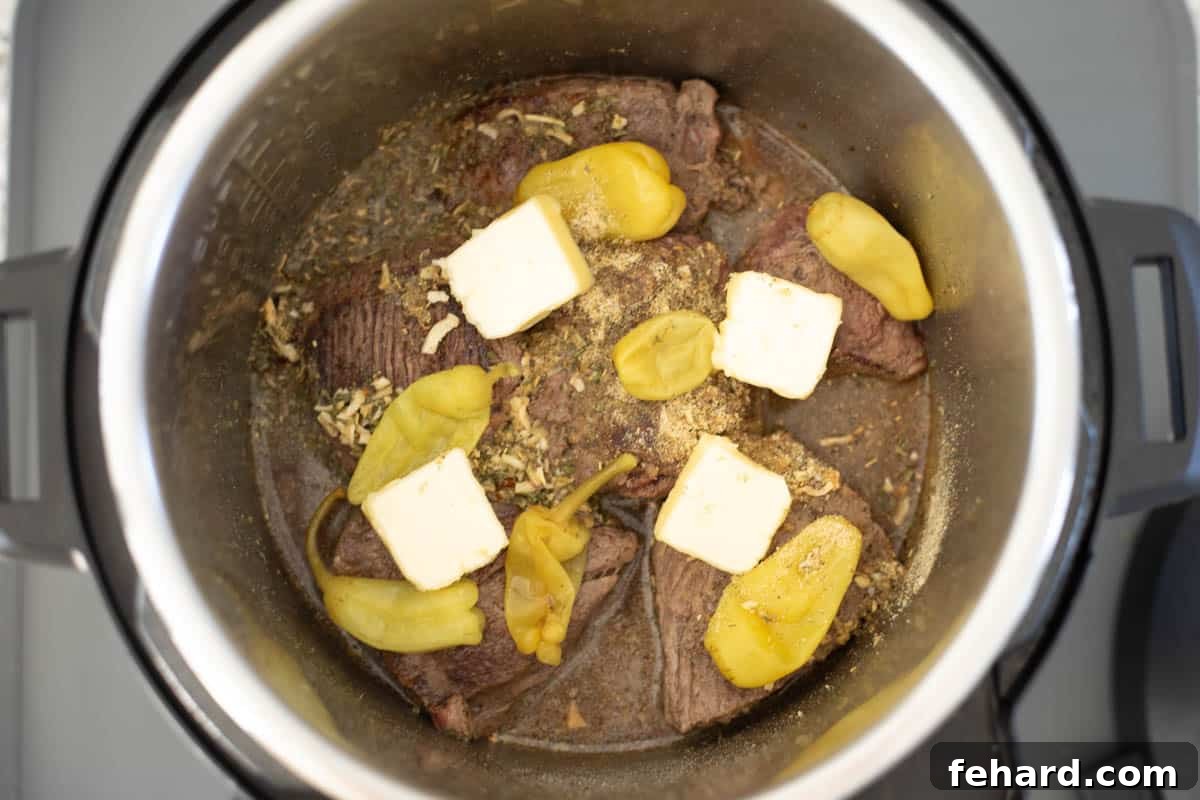 Ingredients for Mississippi Pot Roast in inner pot topped with pats of butter.