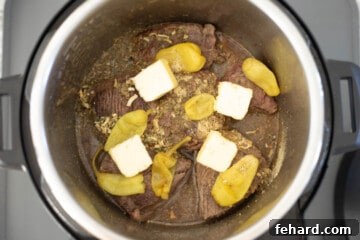 Ingredients for Mississippi Pot Roast in inner pot topped with pats of butter.
