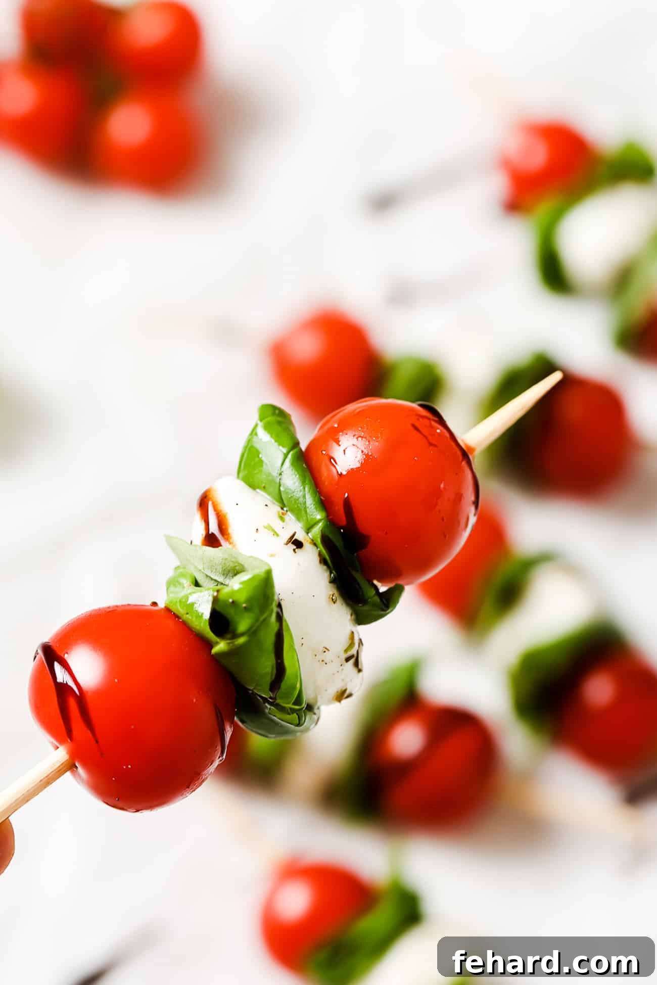 Fresh Caprese Bites 8 A closeup of one caprese skewer drizzled with balsamic reduction.
