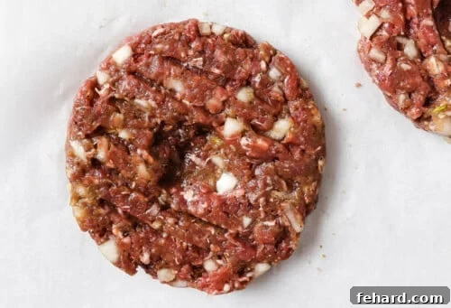 The Ultimate Homemade Burger 9 raw burger patties on a parchment paper.