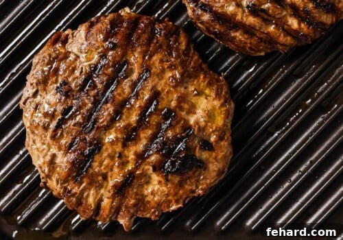 The Ultimate Homemade Burger 10 cooked burger patties on a grill.